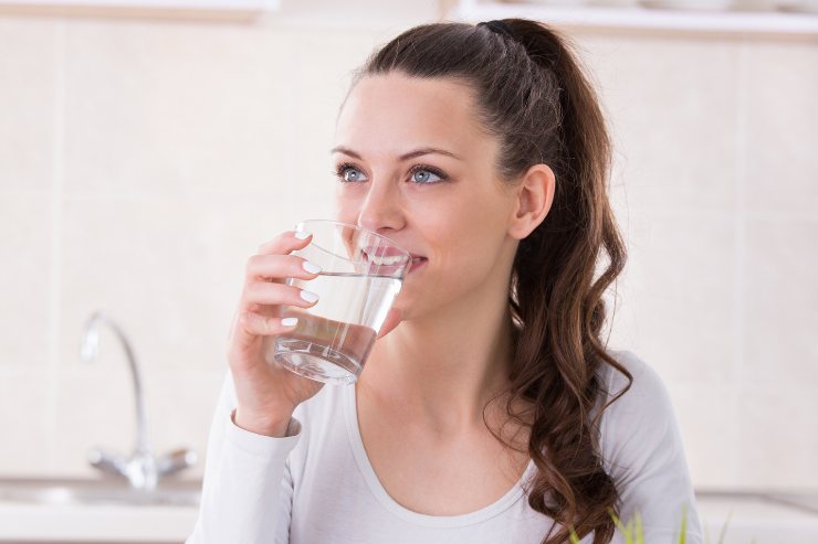 ragazza beve un bicchiere di acqua
