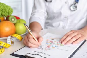 dottoressa scrive e piatto di frutta